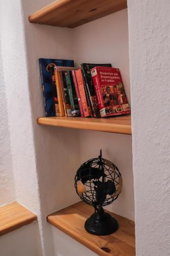 a book shelf with books and a bird cage on it at Ferienwohnung am Herzplatz 2 in Memmelsdorf