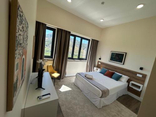 a hotel room with a bed and a table at Escola Da Mestra Da Portela Sampriz in Ponte da Barca