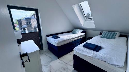 a small room with two beds and a window at Marina Dziwnów Premium Haus in Dziwnów