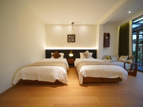 a bedroom with two beds in a room at Huangshan Hongcun Weizhashan Xunxi Hotel in Huangshan