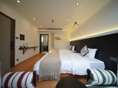a large bedroom with two beds and a couch at Huangshan Hongcun Weizhashan Xunxi Hotel in Huangshan