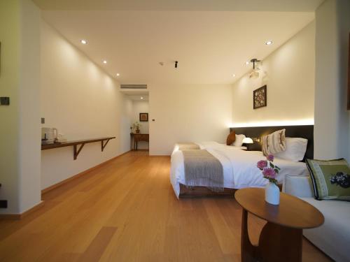a hotel room with a bed and a table at Huangshan Hongcun Weizhashan Xunxi Hotel in Huangshan