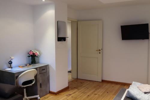 a room with a desk and a chair and a television at Ferienwohnung am Herzplatz 2 in Memmelsdorf