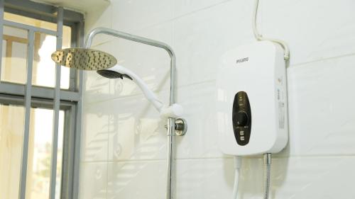 un cabezal de ducha en la pared del baño en KIGALi LODGE APART, en Kigali
