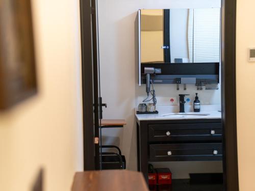 a bathroom with a sink and a mirror at Huangshan Hongcun Weizhashan Xunxi Hotel in Huangshan