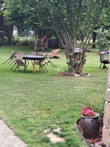 a park with benches and a table and a tree at la hamonniere in Savigny-le-Vieux