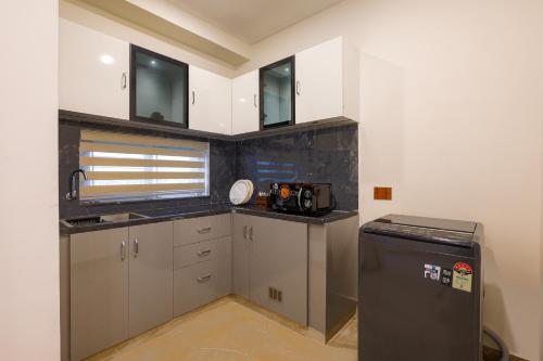 a small kitchen with a sink and a refrigerator at Elysium Studio Suites Madhapur in Hyderabad