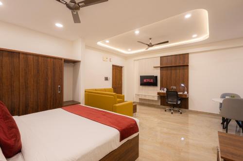 a bedroom with a bed and a desk and a chair at Elysium Studio Suites Madhapur in Hyderabad