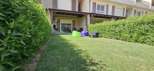 a house with a yard with a green hedge at Duplex - Sea view with a garden at Murano - Ain Sokhna in Ain Sokhna