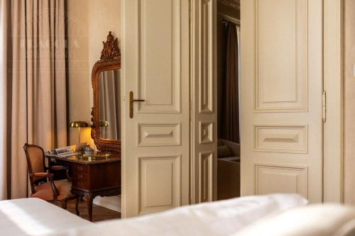 a bedroom with a door and a desk and a mirror at Fragola Apartments Old Town in Kraków