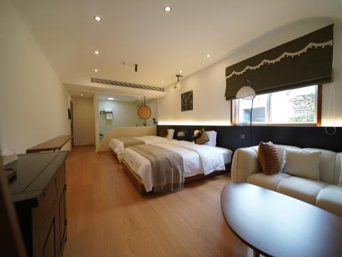 a large bedroom with a bed and a couch at Huangshan Hongcun Weizhashan Xunxi Hotel in Huangshan