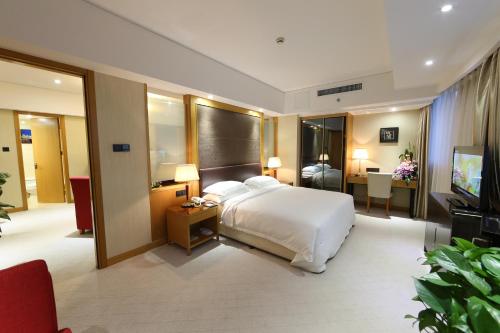 a hotel room with a bed and a television at Aurum International Hotel Xi'an in Xi'an