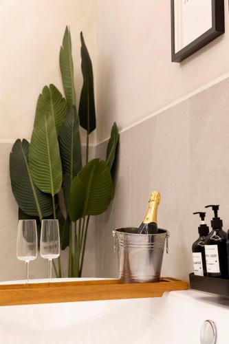 una bottiglia di champagne su uno scaffale con due bicchieri di vino di Falco Deluxe Home a Napoli
