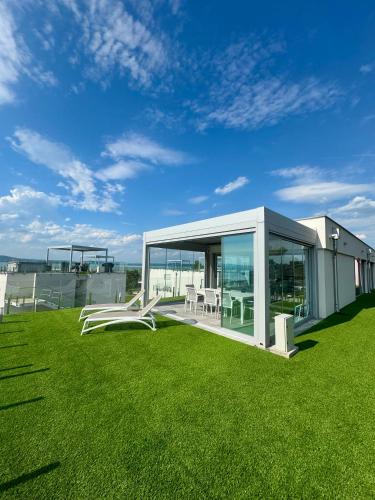a house with a glass extension on a grass field at Villapark apartman A-B 12 in Fonyód