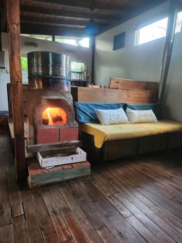a room with a bed and a wood stove at Cabaña el colibri in Mar del Plata
