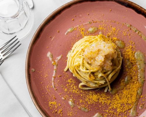 a plate of pasta with sauce and cheese on it at Locanda Expanificio in Agrigento