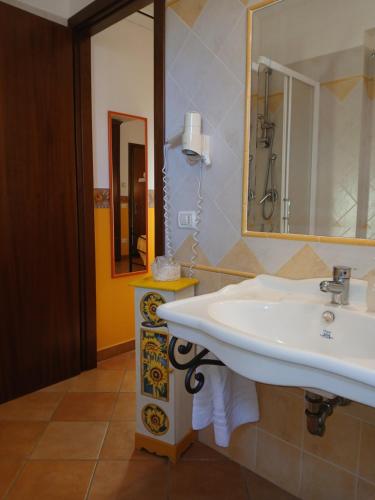 un bagno con lavandino e specchio di Agriturismo Le Quattro Stagioni a Viterbo