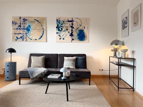un soggiorno con un divano e un tavolo di City-Close - King Bed & Free Garage a Bayreuth