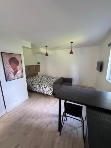 ein Schlafzimmer mit einem Bett und einem Schreibtisch in einem Zimmer in der Unterkunft Studio Éloi Ducom - Mont de Marsan in Mont-de-Marsan