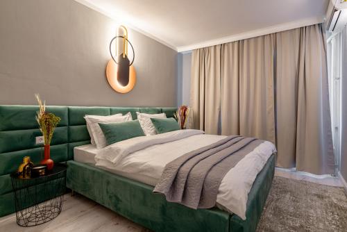 - une chambre avec un canapé vert et un lit dans l'établissement Golden Glow Hideaway, à Bucarest