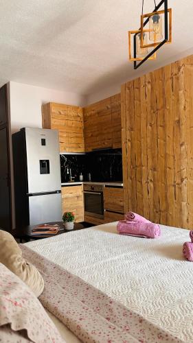 a bedroom with a bed and a kitchen with a refrigerator at Black Flox AparTment in Drama