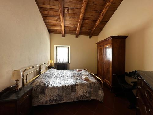 a bedroom with a bed and a wooden ceiling at Dormo in mulino in Bagnasco