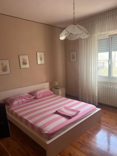 a bedroom with a large bed with a pink blanket at Casa Elena in Sistiana
