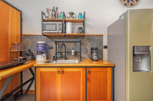 a kitchen with a sink and a refrigerator at Aloki Wim 4 A pasos de la Playa in Punta Uva