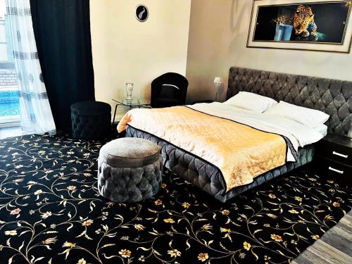 a bedroom with a bed and a ottoman at Diamond Hotel in Chişinău