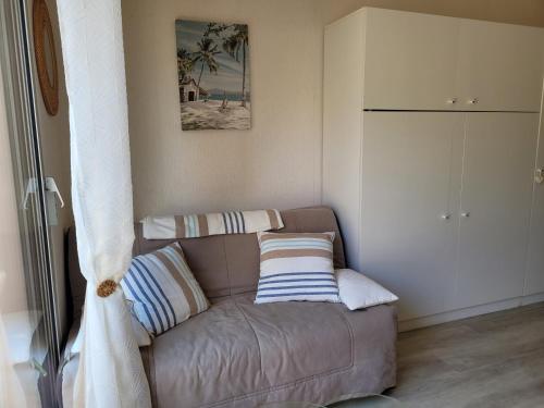 un salon avec un canapé marron avec des coussins rayés dans l'établissement La Madrague, à Saint-Laurent-du-Var