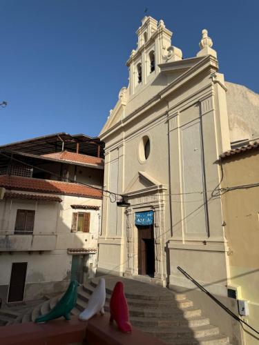a white building with a tower with a steeple at Il Lanternino in Tropea