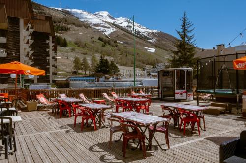 a group of tables and chairs on a deck at Atmosphere Hotel in Les Deux Alpes