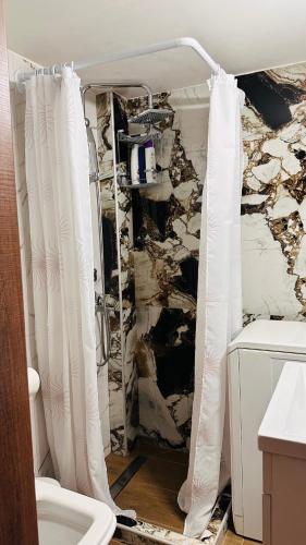 a bathroom with a stone wall and a toilet at Black Flox AparTment in Drama