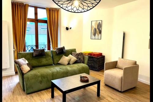 - un salon avec un canapé vert et une chaise dans l'établissement Spacious apartment in the heart of Gerardmer !!!, à Gérardmer