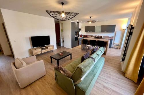 un salon avec un canapé, des chaises et une télévision dans l'établissement Spacious apartment in the heart of Gerardmer !!!, à Gérardmer