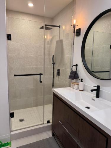 a bathroom with a glass shower and a sink at Casa de Leon Lakeview Guesthouse in Mississauga