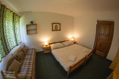 a bedroom with a bed and a couch in it at Třetí chalupa U Smrčiny in Janske Lazne
