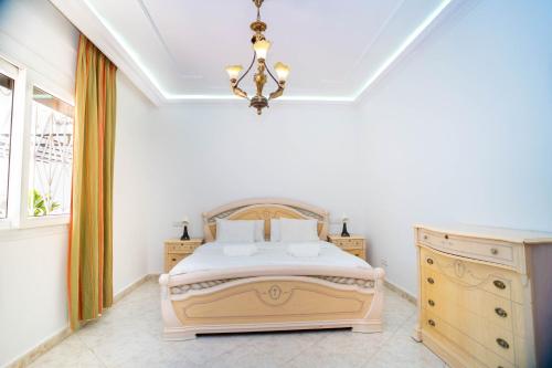 丹吉尔Encantadora casa céntrica的一间卧室配有一张床、梳妆台和吊灯。