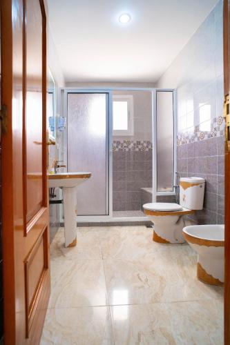 a bathroom with two sinks and a toilet and a shower at Encantadora casa céntrica in Tangier