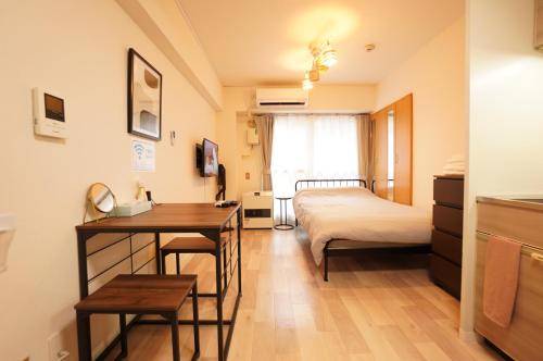 a bedroom with a bed and a desk and a table at Residence Hotel #2 エアコン付き 無料Wi-Fi in Sapporo