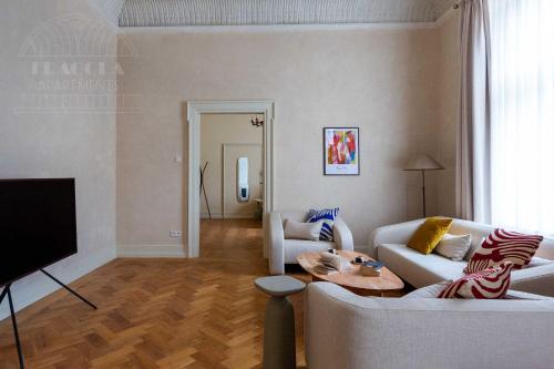 a living room with two white couches and a table at Fragola Apartments Old Town in Kraków