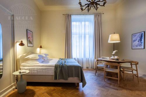 a bedroom with a bed and a table and a window at Fragola Apartments Old Town in Kraków