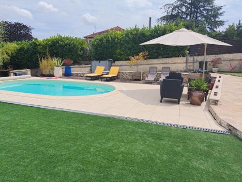 - une piscine avec des chaises et un parasol à côté d'une cour dans l'établissement Le Petit Cocon - Parking privé - Lyon Sud, à Vénissieux