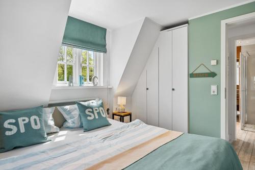 una camera da letto con un letto grande con cuscini blu di Strandnest a Sankt Peter-Ording