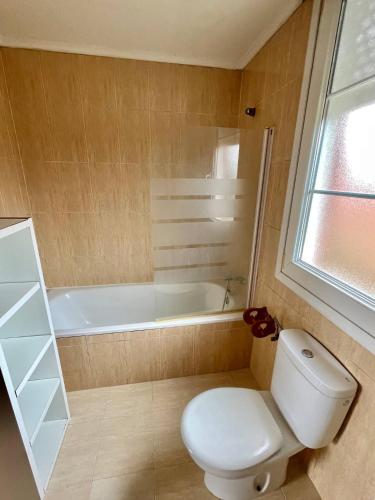 a bathroom with a toilet and a bath tub at Chalet adosado con amplio jardín in Cubas
