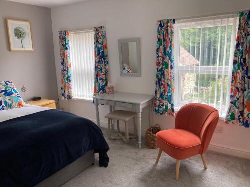 een slaapkamer met een bed, een bureau en een stoel bij Ludford View, riverside cottage in Ludlow with private parking in Ludlow
