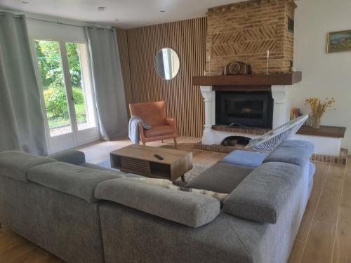 a living room with a couch and a fireplace at La Pomme d'Or Maison 8 personnes in Sainte-Opportune-la-Mare