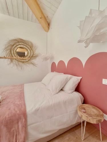 a bedroom with a pink and white bed and a table at La Rose des Sables suite 5 étoiles villa Côté Cœur in Les Issambres