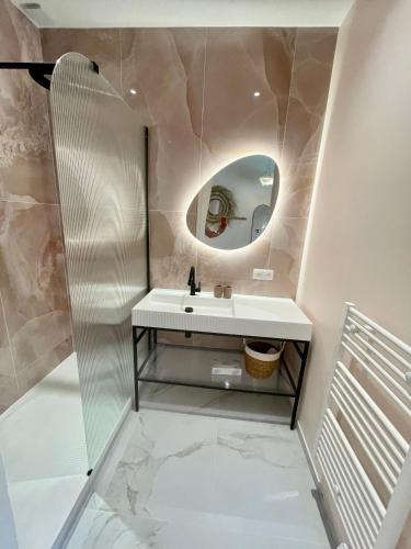 a bathroom with a sink and a mirror at La Rose des Sables suite 5 étoiles villa Côté Cœur in Les Issambres