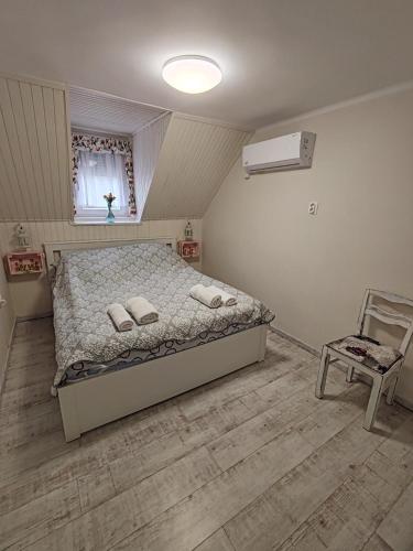 a bedroom with a bed and a chair in it at FYRED Vintage Apartman in Tiszafüred